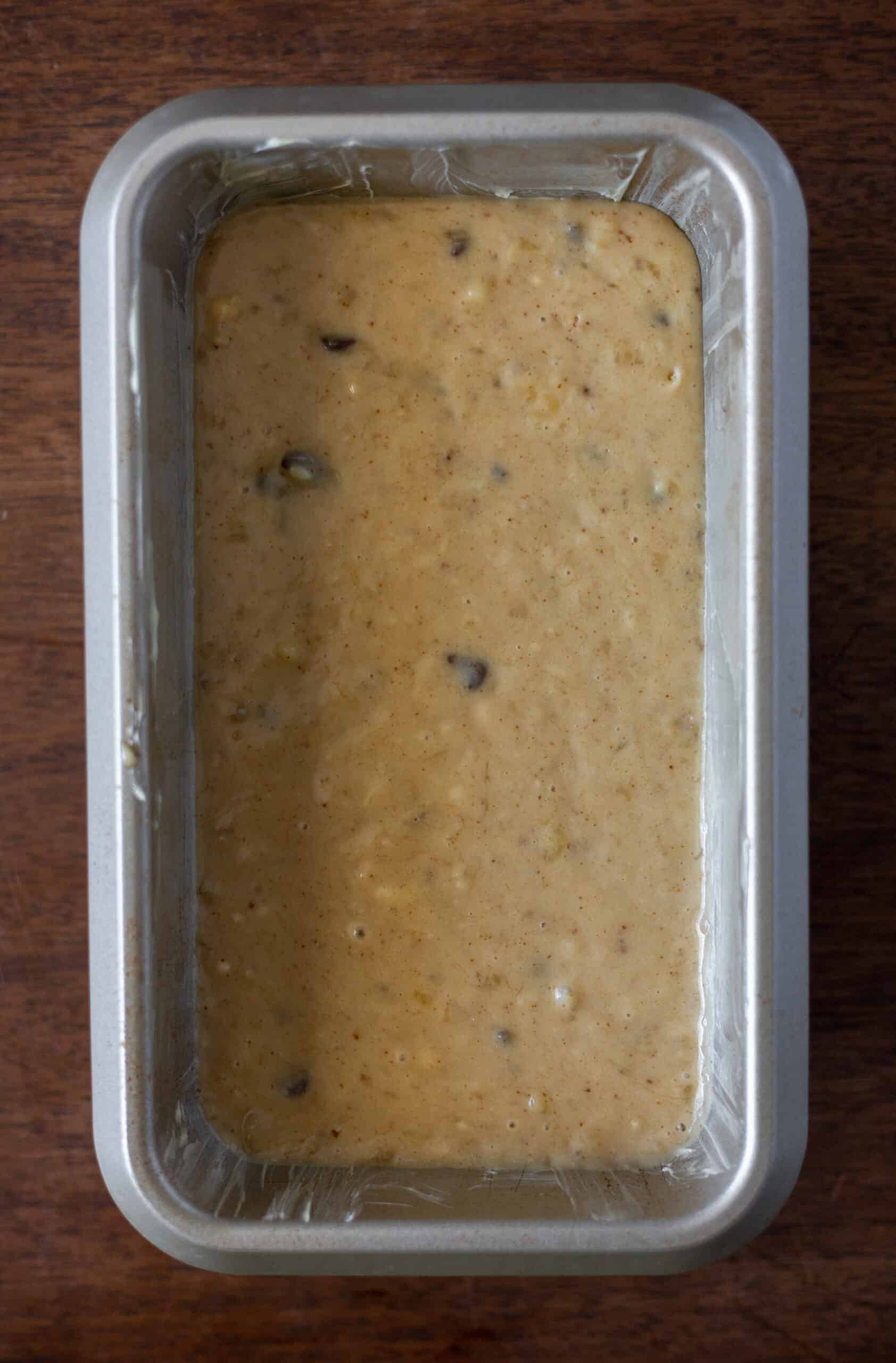 Banana bread batter poured into greased loaf pan
