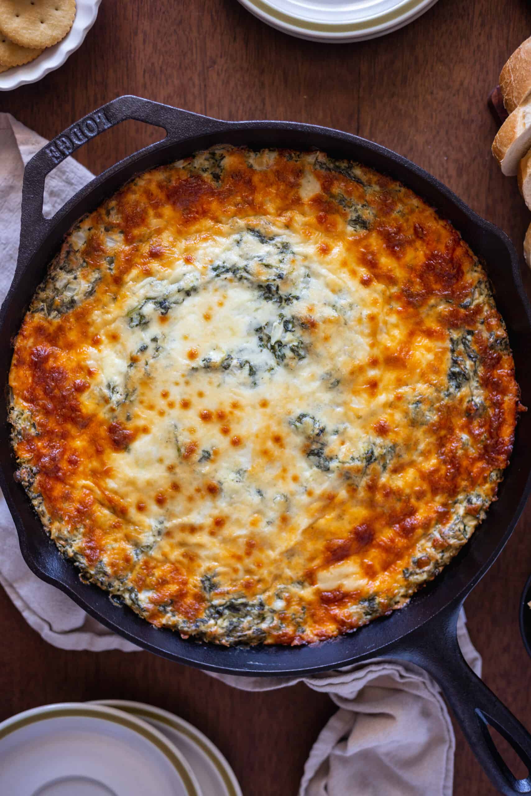 Large cast iron filled with bubbly spinach artichoke dip