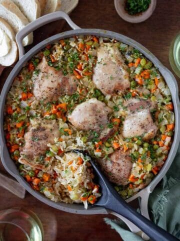 Big pan of chicken and rice with large spoon in it