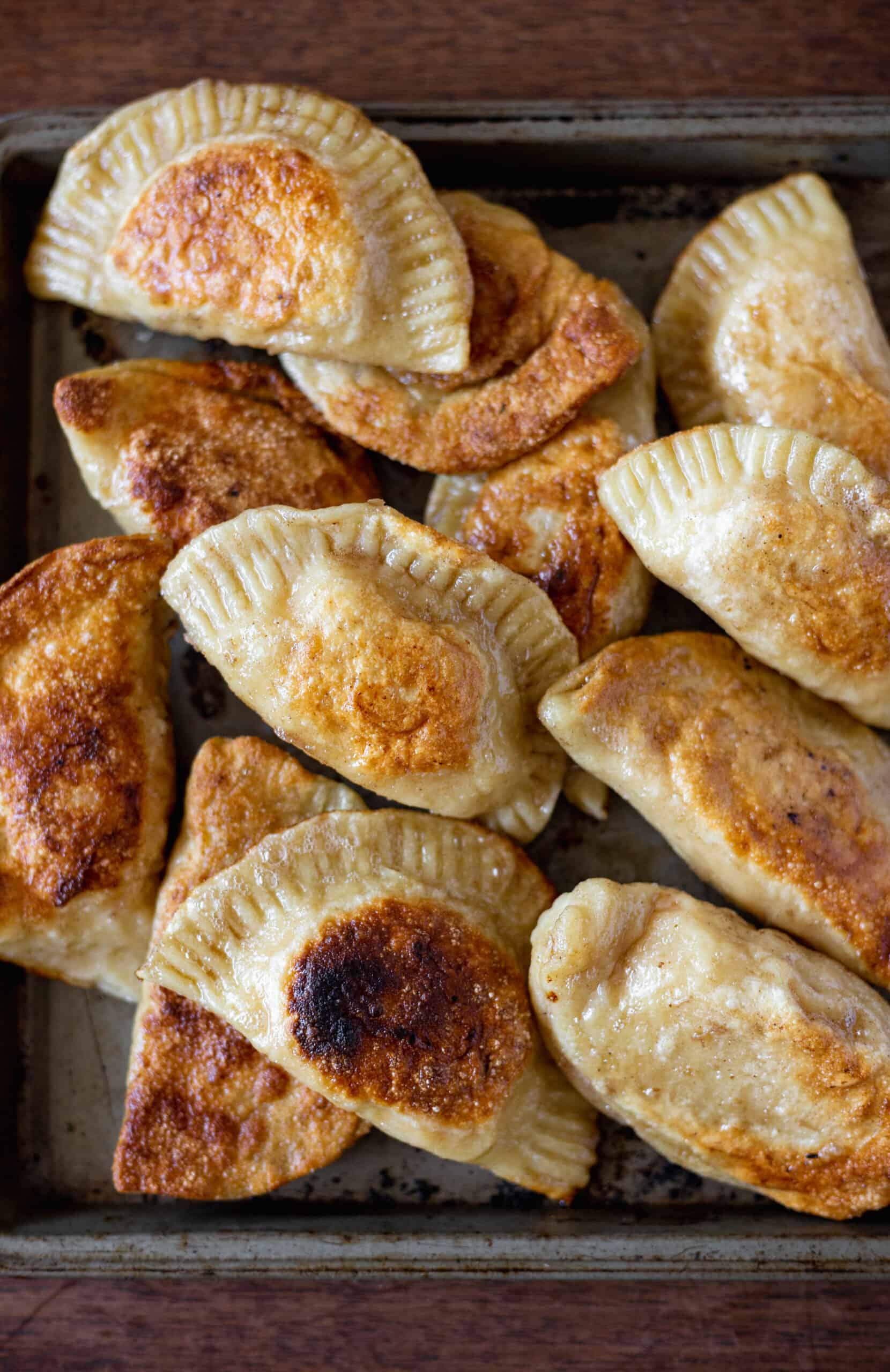 Pierogi after being sauteed are golden brown in a pan