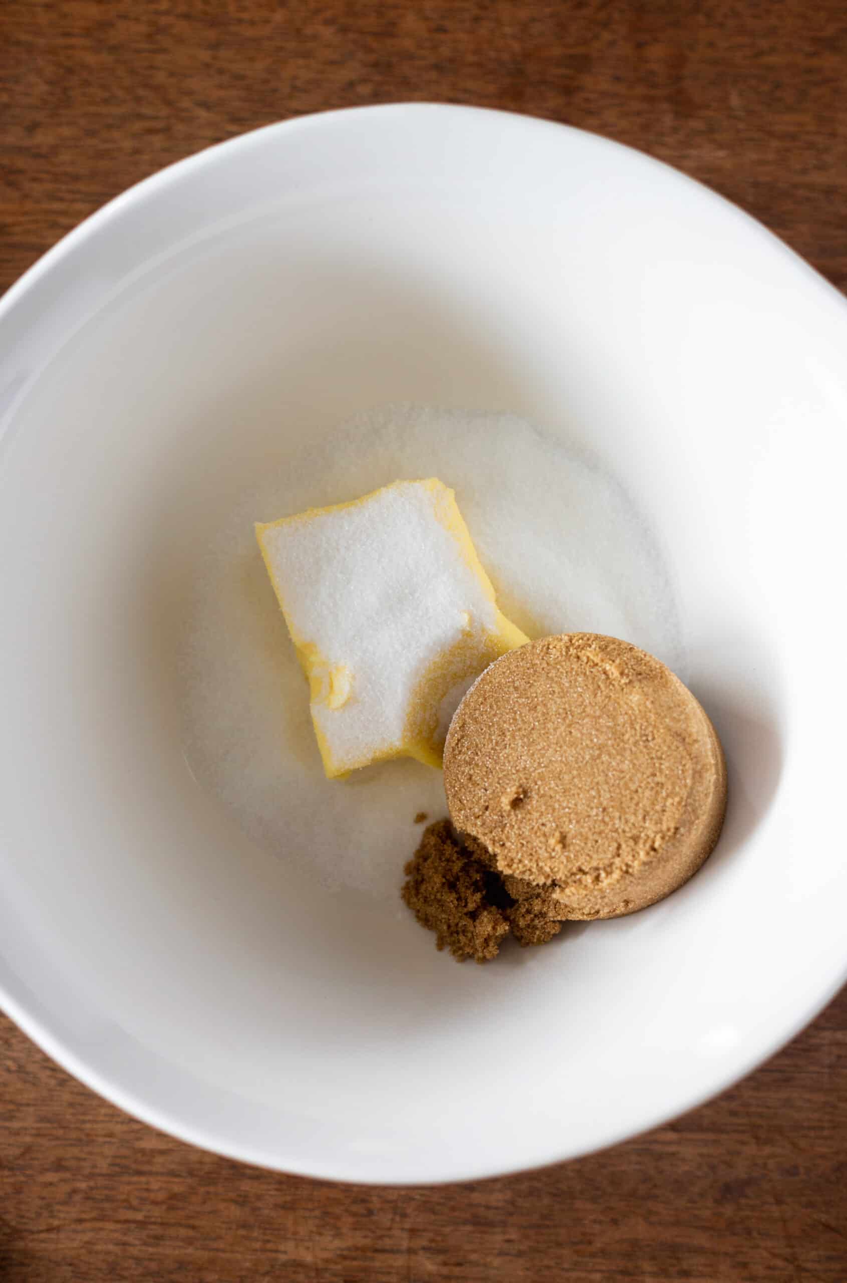 Butter and sugars in a large white bowl