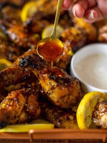 Lemon wings being drizzled in hot sauce