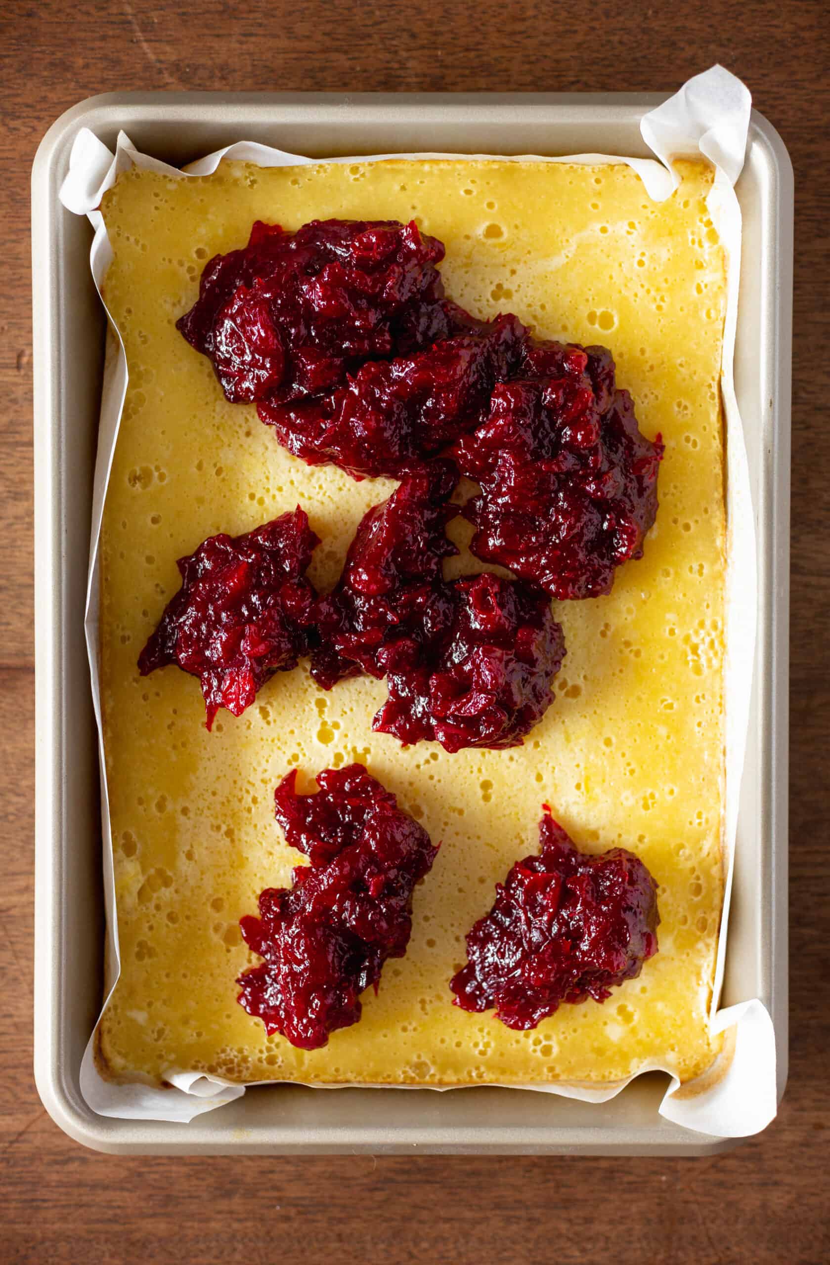 Scoops of cranberry placed on lemon bars