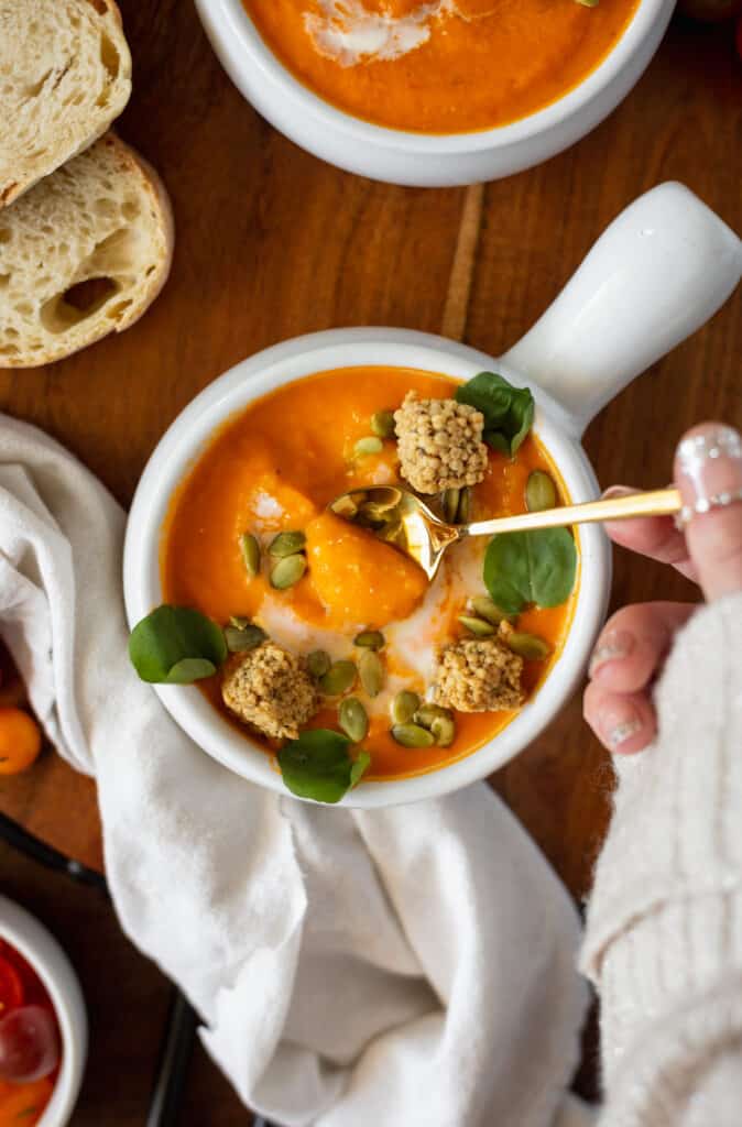 Bowl of tomato soup with a gold spoon