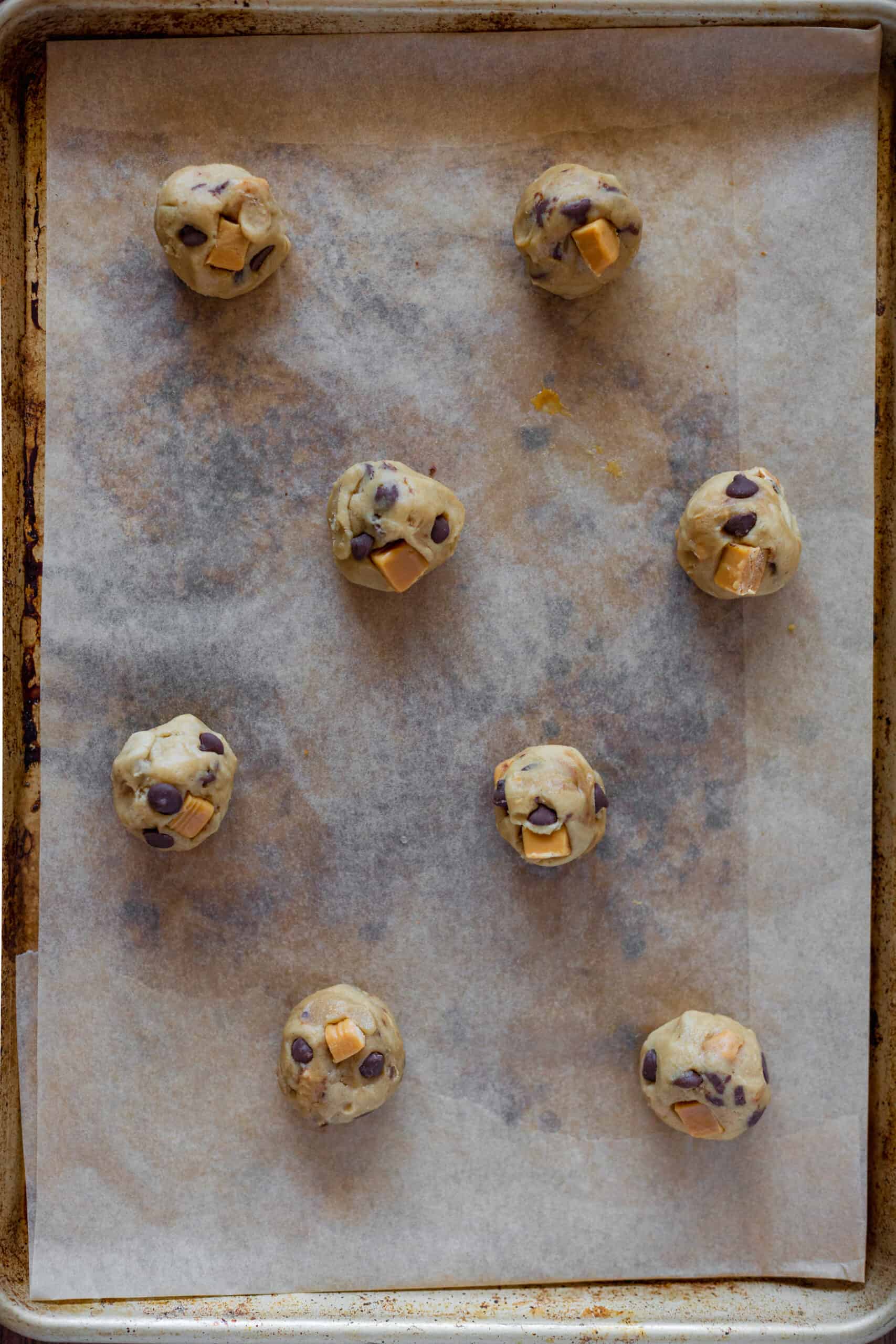 cookie dough balls on a line sheet pan