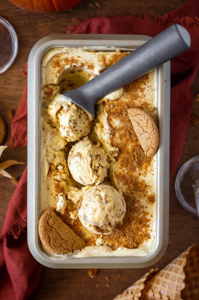 loaf pan of pumpkin cheesecake ice cream with a scooper
