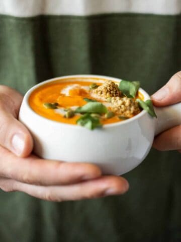 Big bowl of tomato soup being held