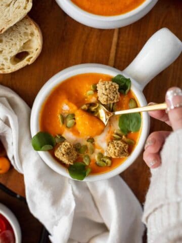 Bowl of tomato soup with a gold spoon