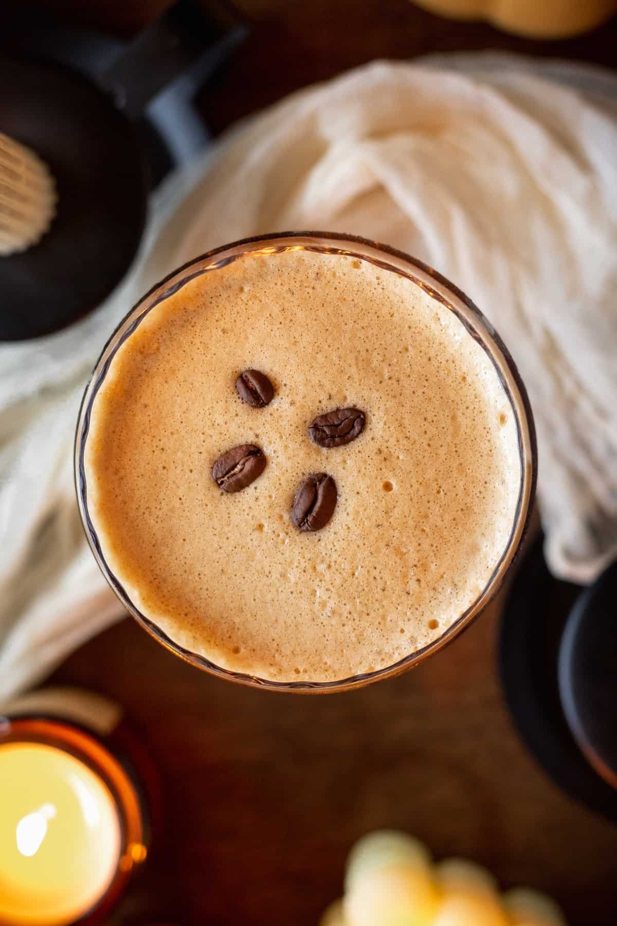 An overhead shot of a pumpkin espresso martini with 4 coffee beans on top