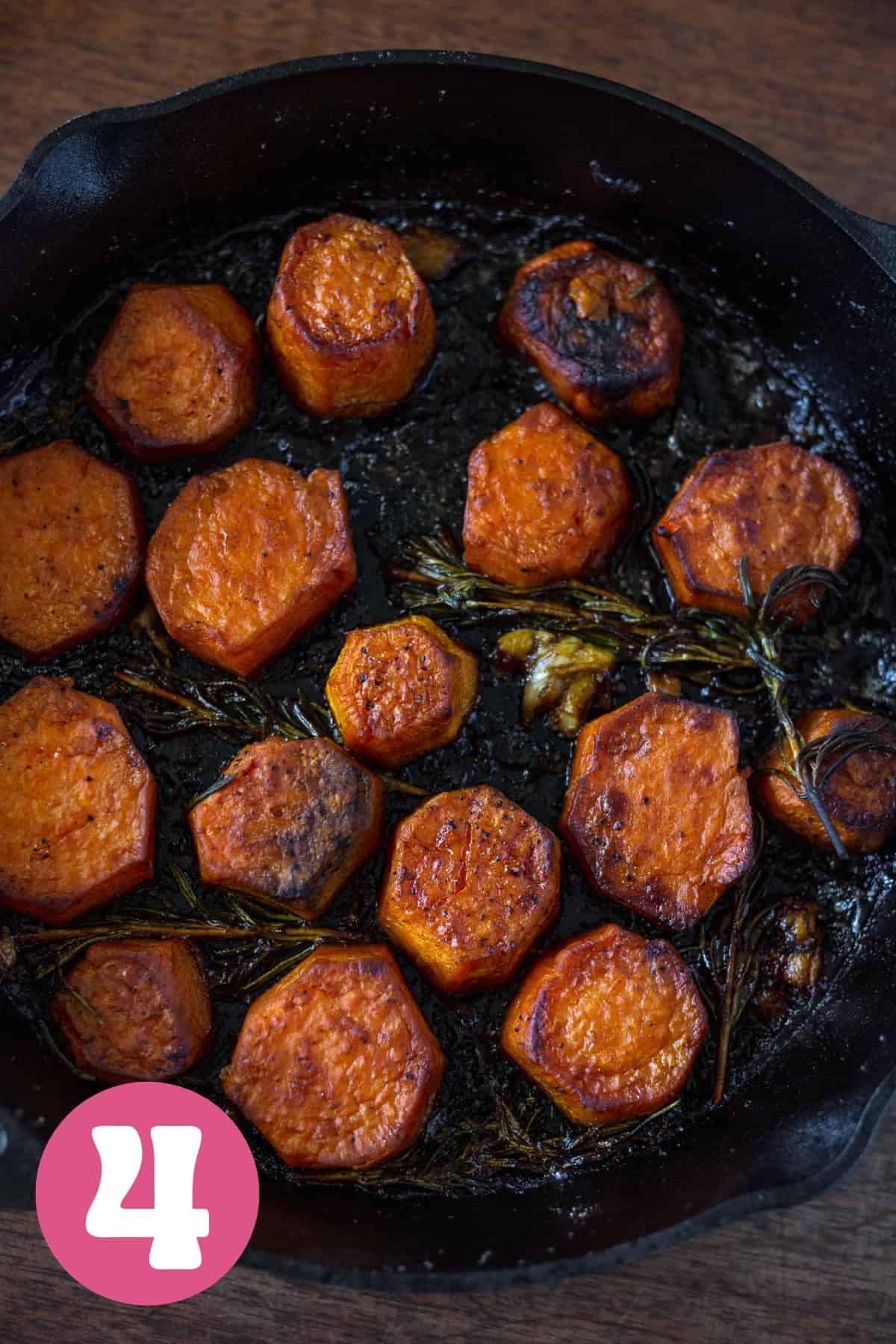 A cast iron pan filled with fondant sweet potatoes finished baking