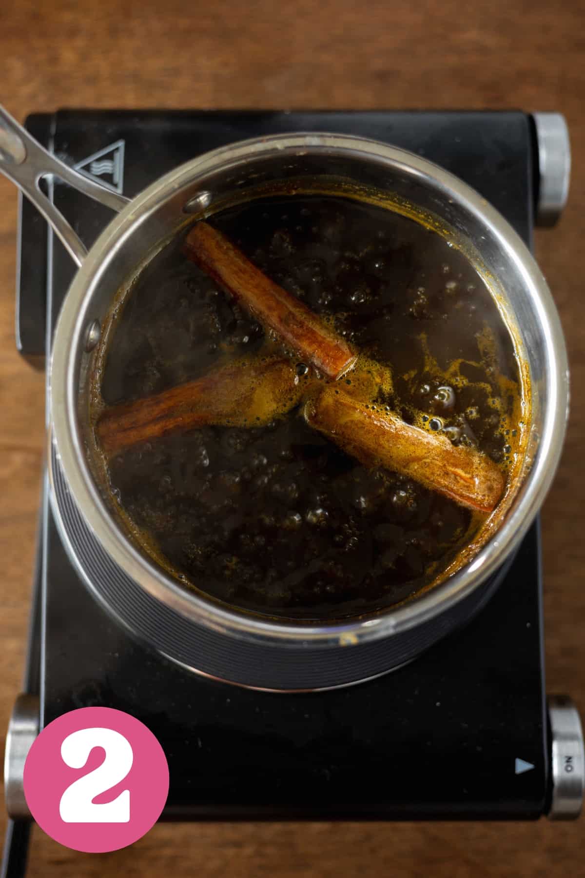 cinnamon sticks boiling in a small pot to make pumpkin spice syrup