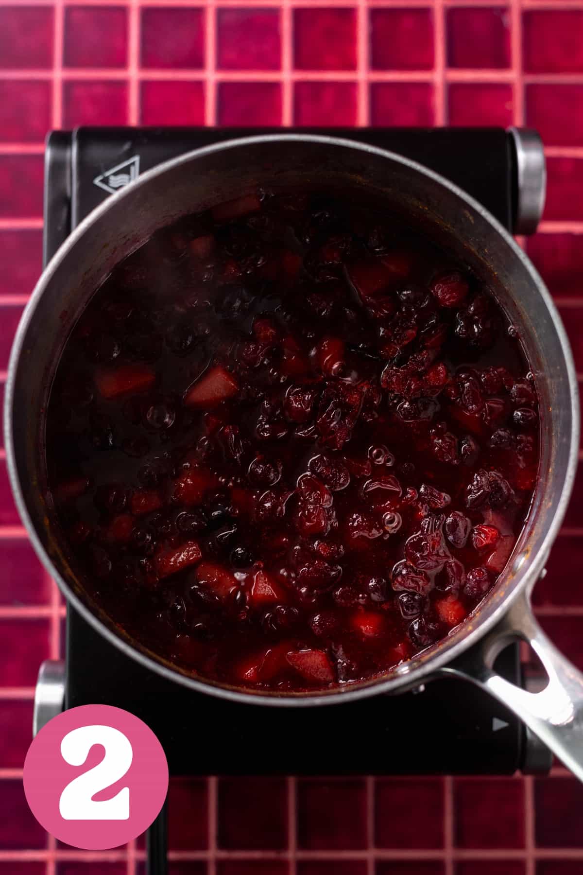 A pot of simmering cranberry sauce labeled step two