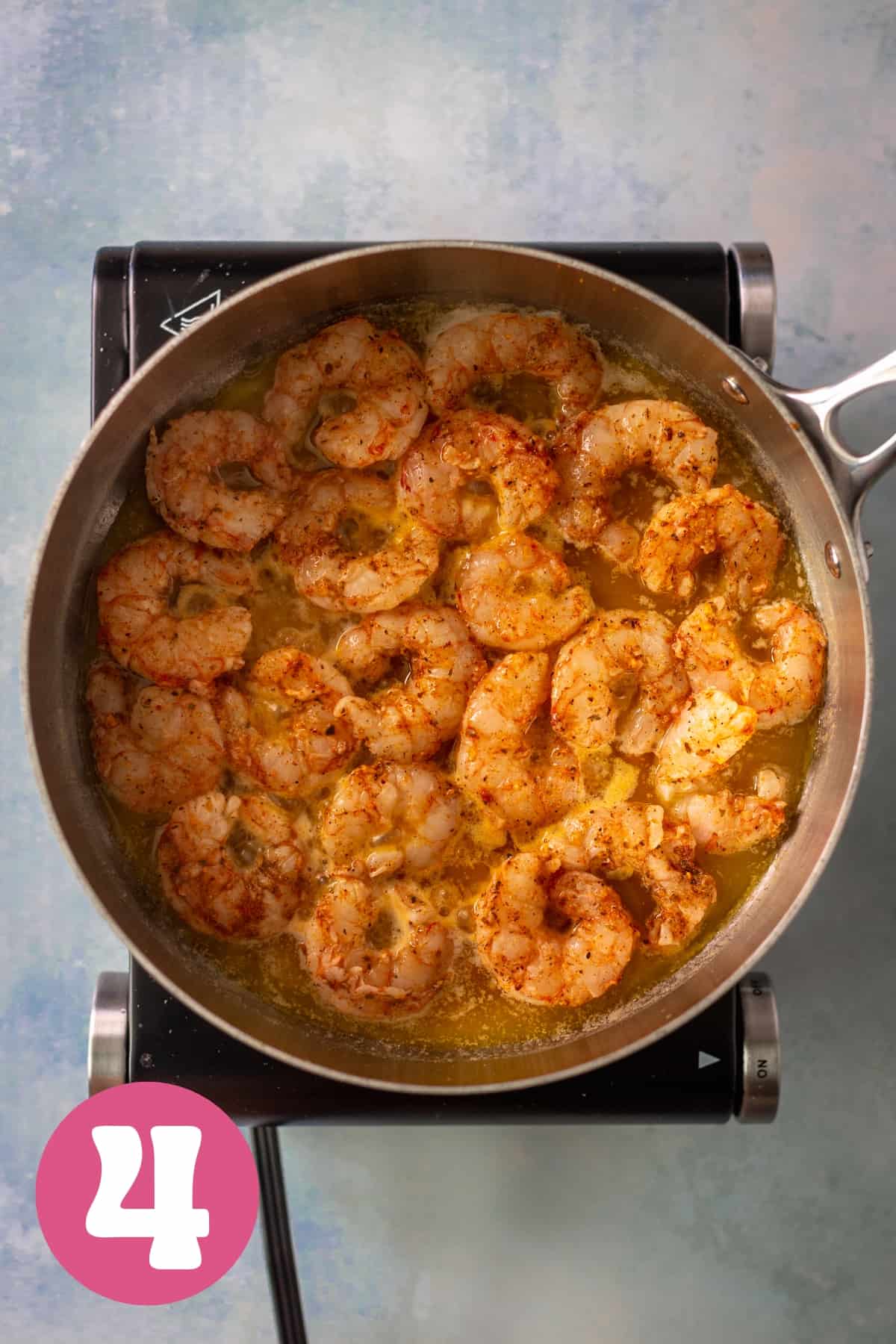 Raw shrimp sauteeing in butter in a large saucepan labeled step 4