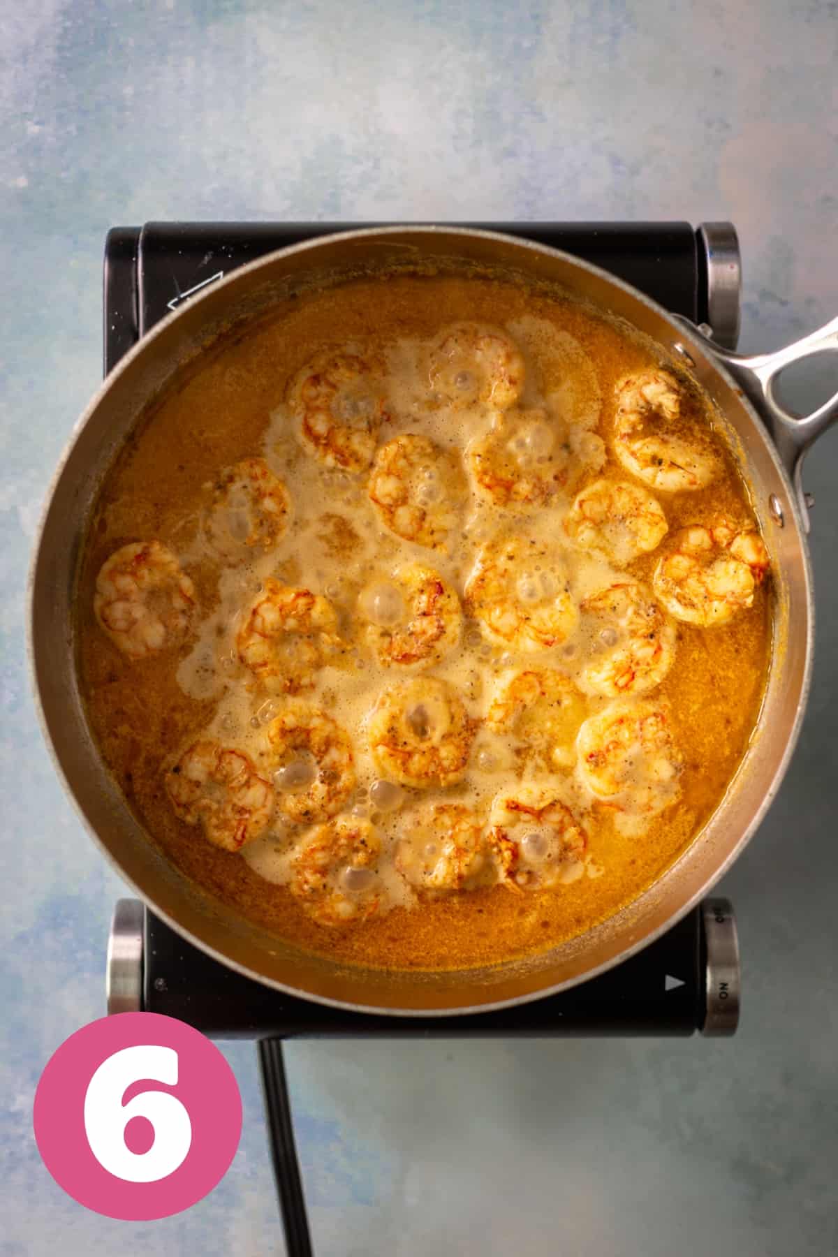 simmering shrimp scampi in a large saucepan labeled step 6