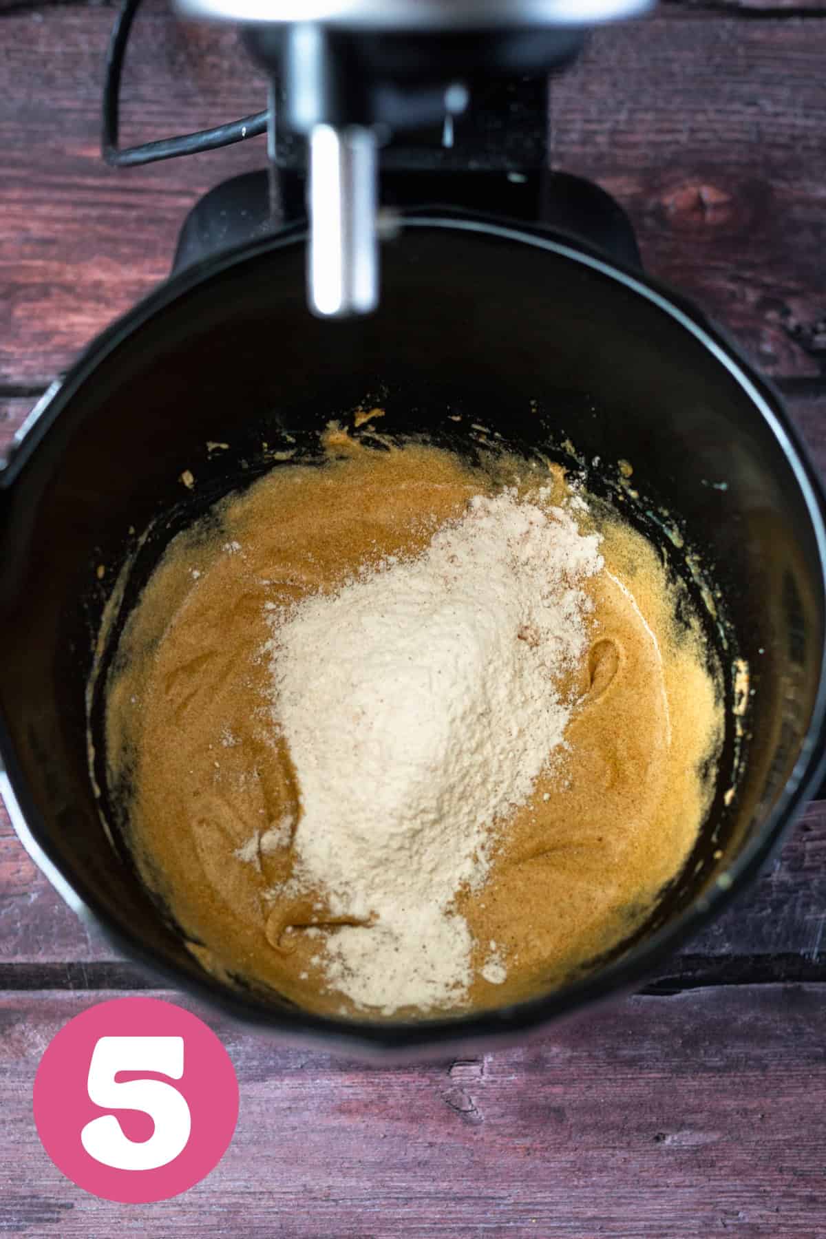 Flour and wet cookie dough ingredients in a bowl