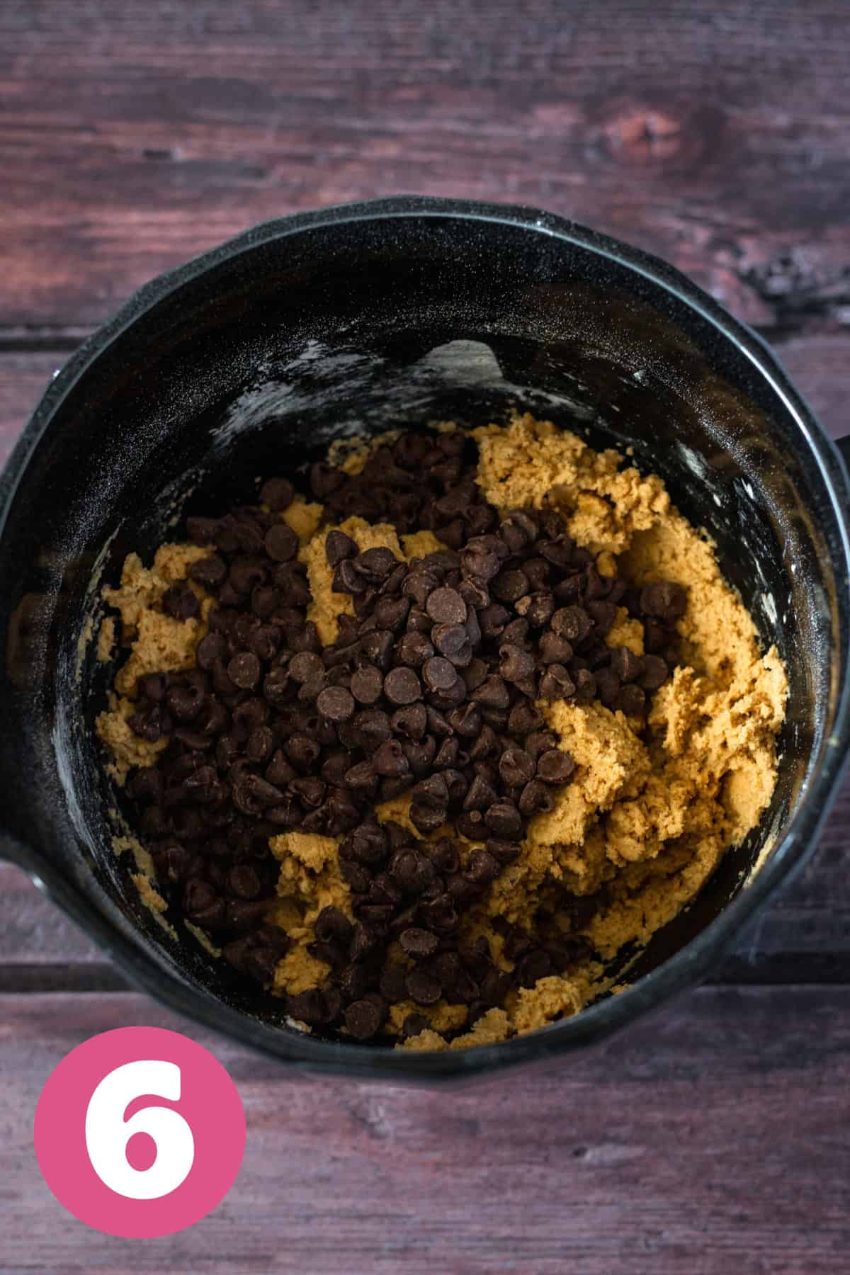 Large bowl of chocolate chip cookies dough with chocolate chips on top