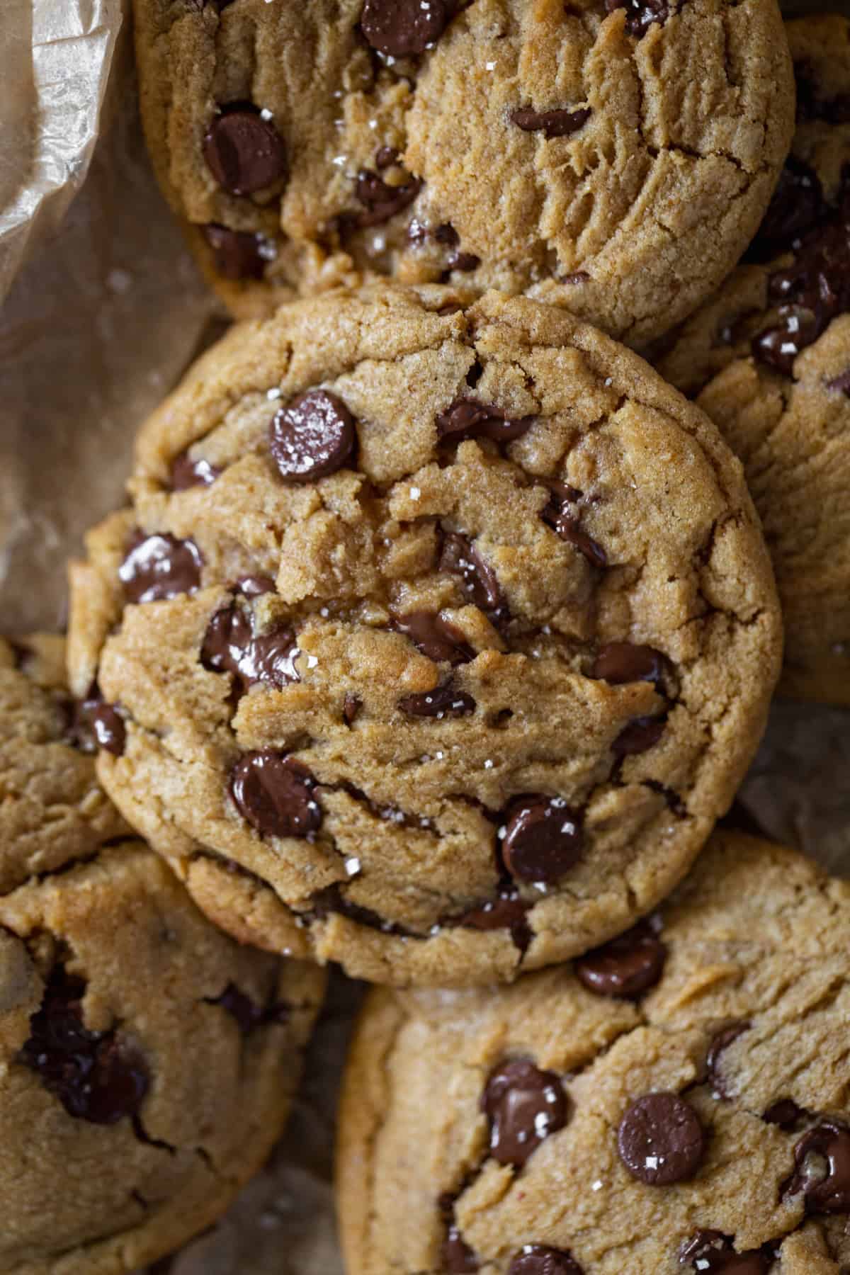 A pile of chocolate chip cookies with melted chocolate
