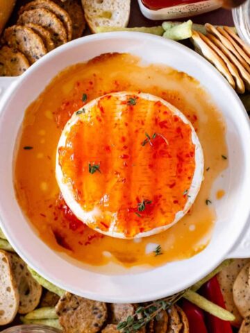 Baked brie in a brie dish with spicy jelly on top