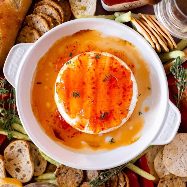 Baked brie in a brie dish with spicy jelly on top