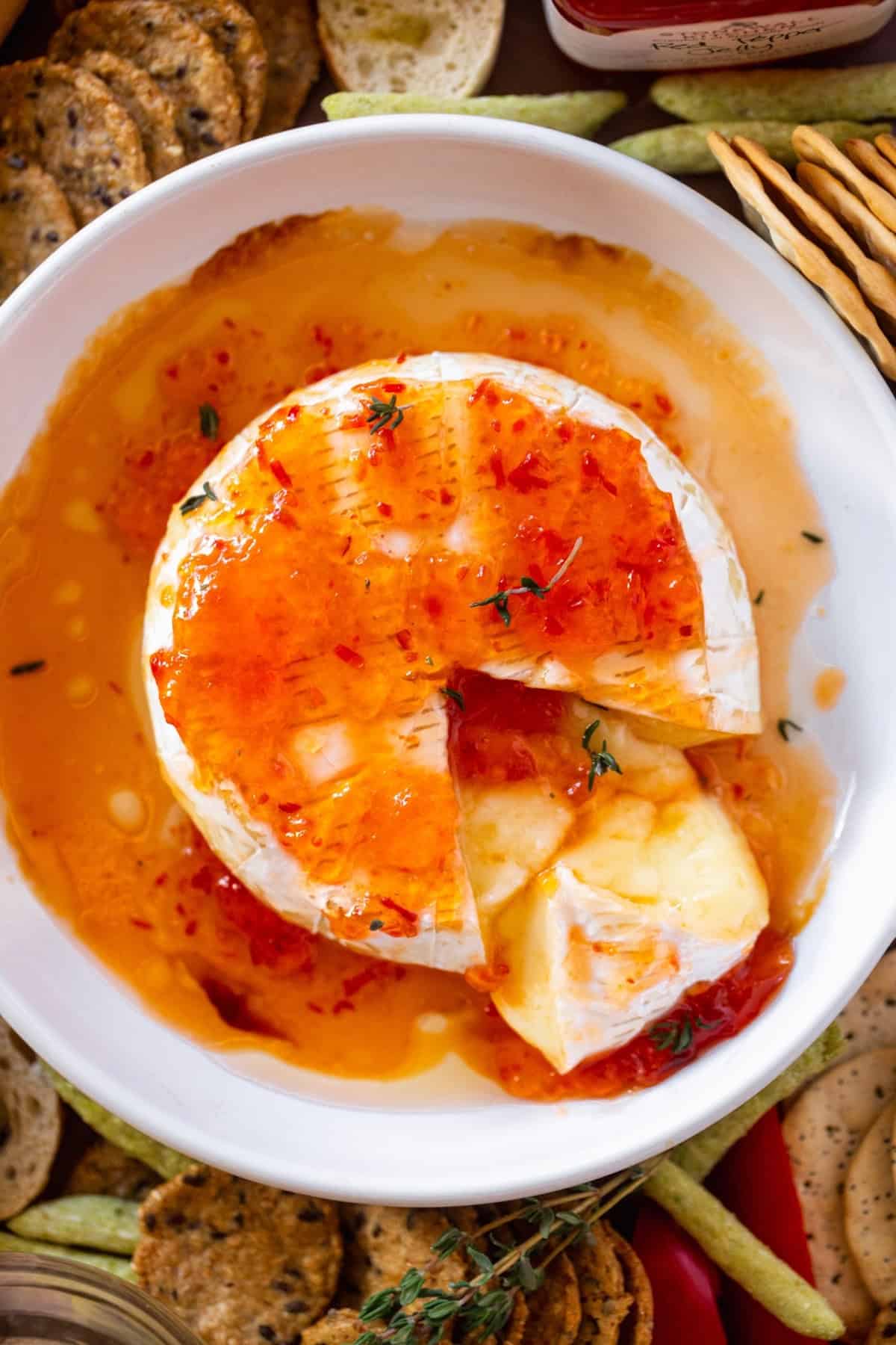 Brie with a wedge cut out coated in red jelly