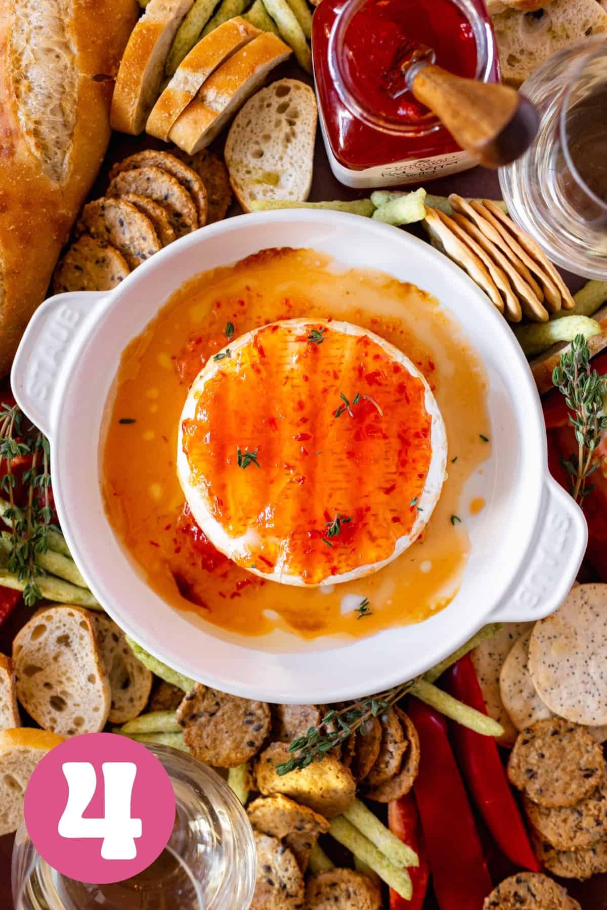 Platter of crackers and vegetables with baked brie in the middle